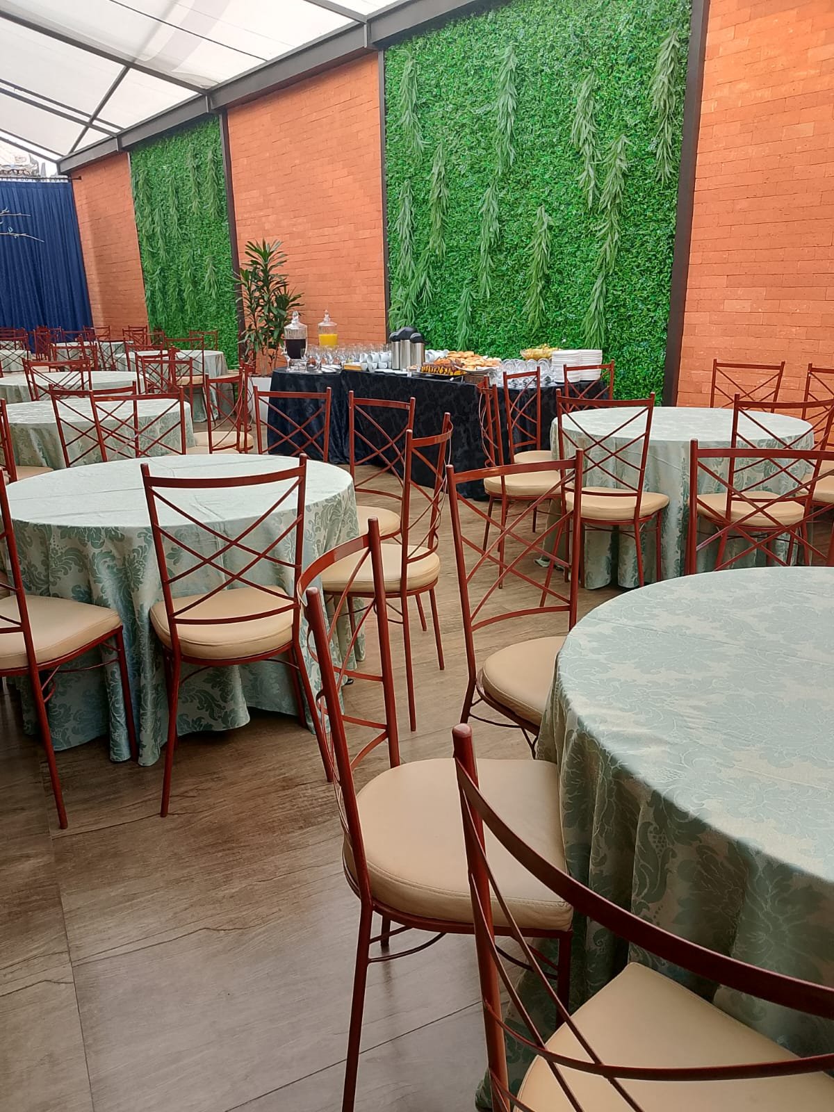 Mesa de coffee break montada com toalhas verdes